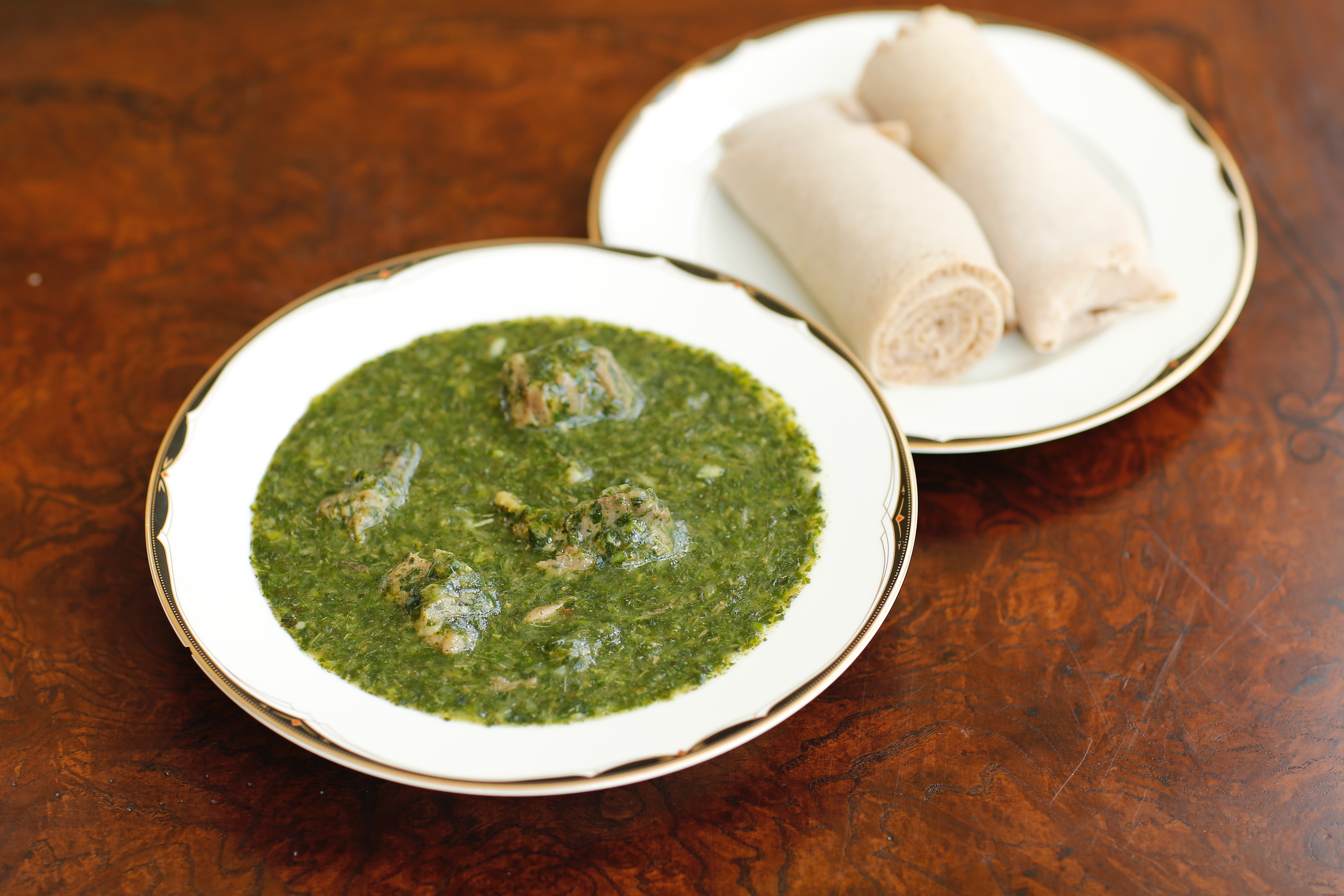 Pictured above is Molokhia cooked in lamb meat, ready to eat, with Injera. South Sudanese Cuisine.